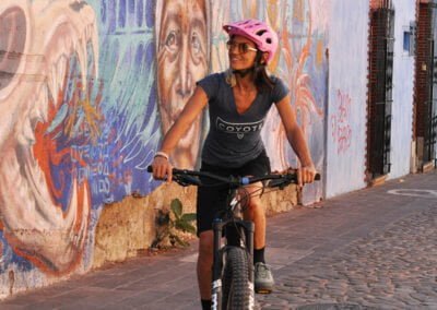 A person riding bike while looking at street art wall