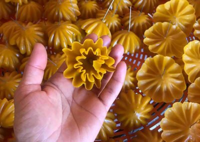 a hand holding a flower shaped candle