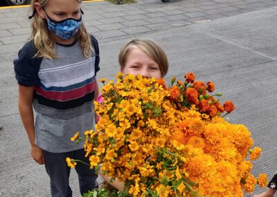 a boy and girl holding a bucket of flowers