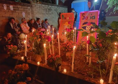 a group of people sitting in a cemetery with candles
