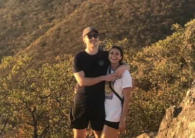 Two person holding in front of a mountain