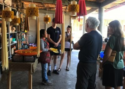 A group of people listening to the instructor of floral candle making