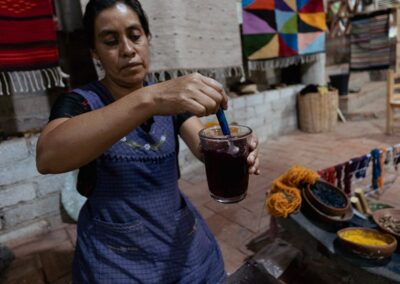 A person stirring a glass of textile's dye