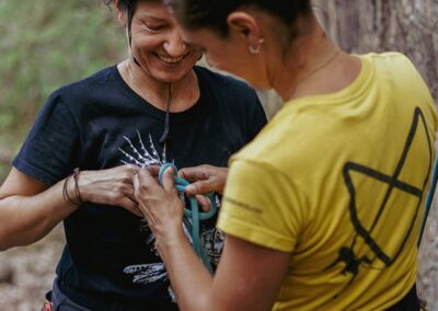 A person help another person to put on a safety rope for rock climbing