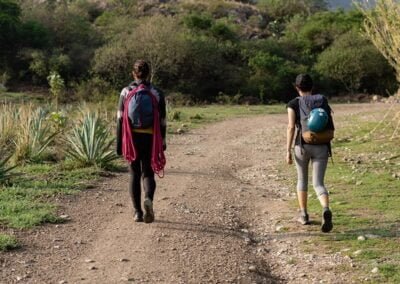 Two people walking while carrying a backpack