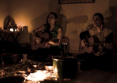 Two people playing guitar while singing