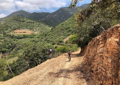 A person riding a bike near rock cliff with natural scenery