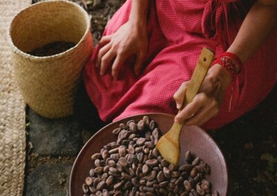 A person stirring chocolate beans on the pottery plate