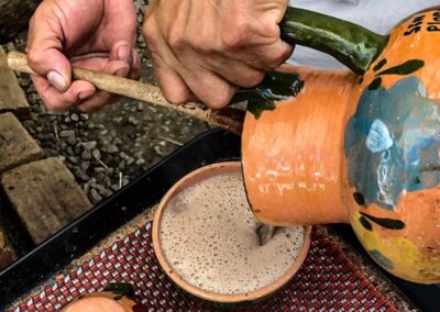 Hands pouring hot chocolate into a bowl