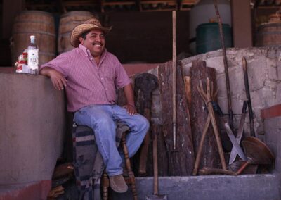 a man sitting on a stool with a hat and tools