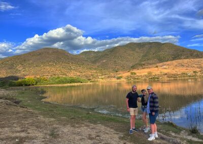 Three people in front of a lake