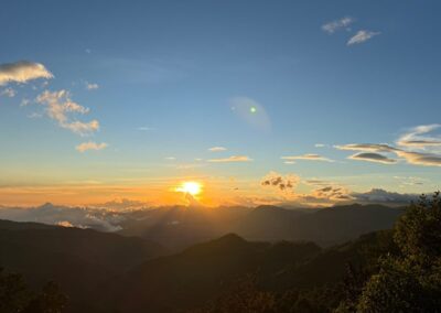 a sunset over mountains and clouds