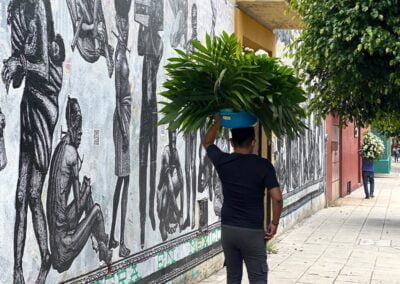 A man holding a bucket of leaves in the of his head